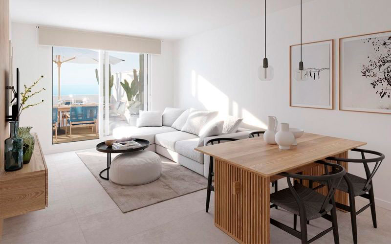 Salón luminoso con sofá blanco, mesa de comedor de madera y terraza al fondo